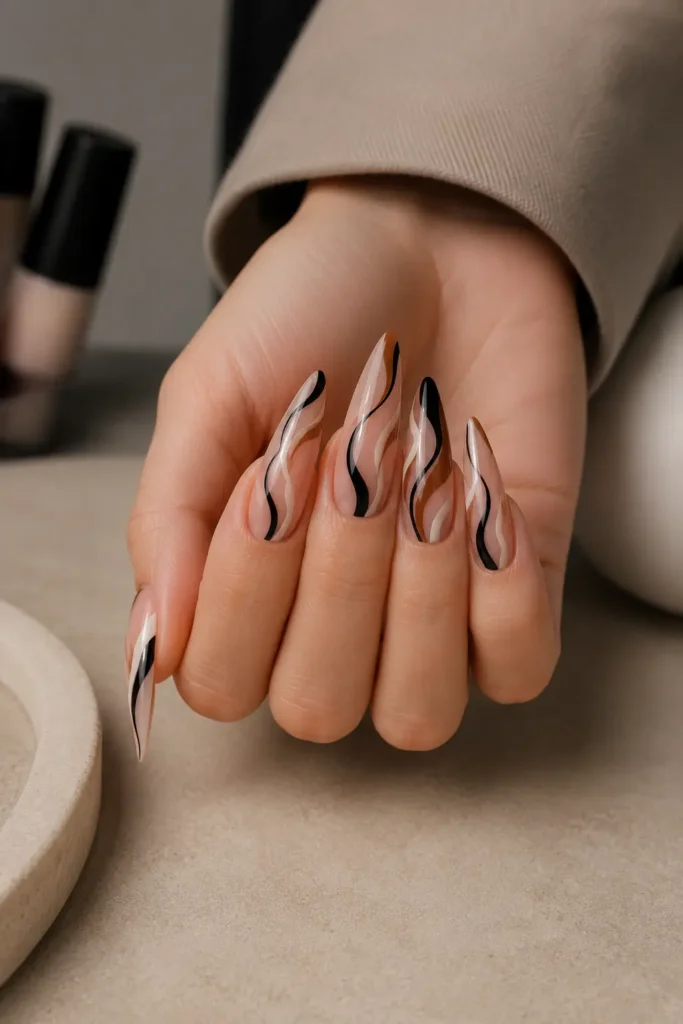Abstract swirl stiletto nail idea in cream and black