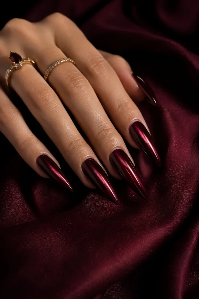 Burgundy cat-eye stiletto nail idea with a shimmering effect