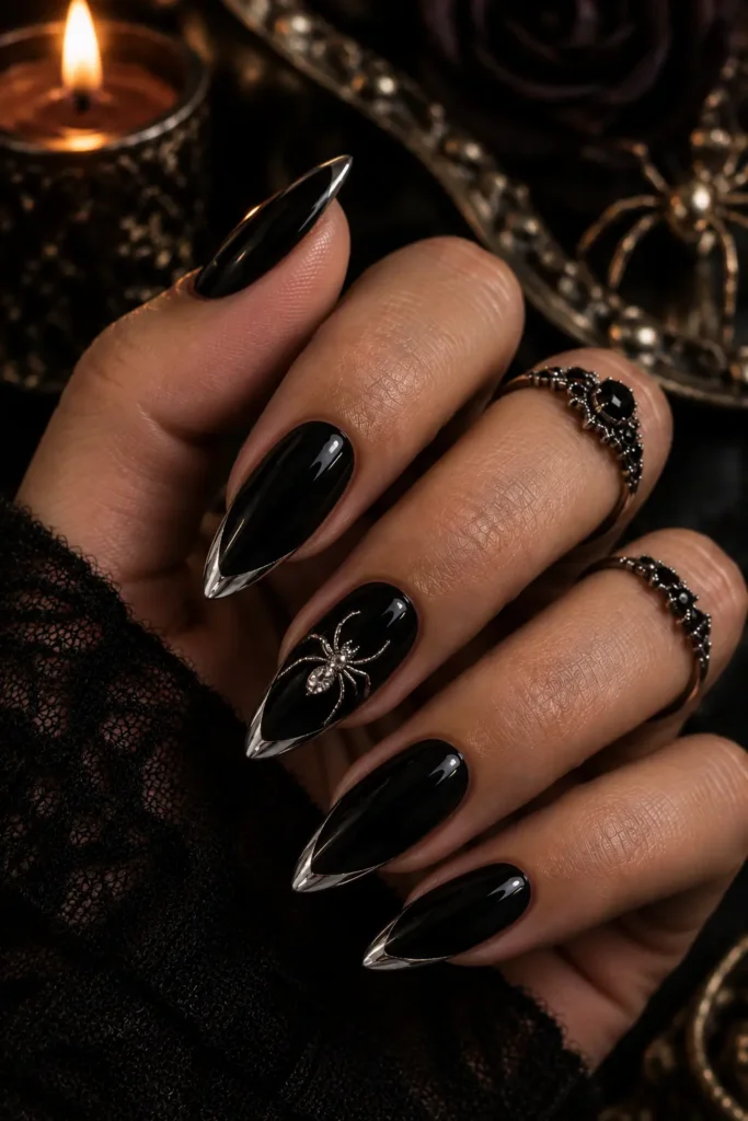 Glossy black almond nails with a raised silver spider