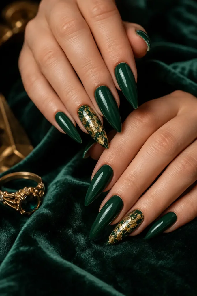 Long stiletto nails in deep emerald green gloss with a gold foil accent
