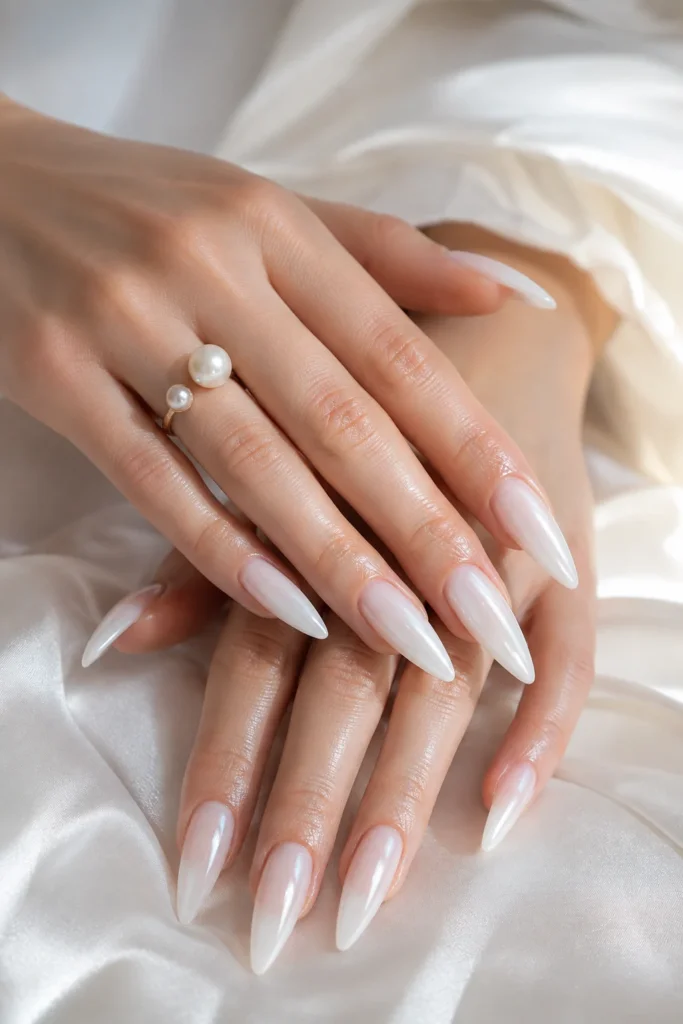 Long stiletto nails coated in soft, translucent milky white polish