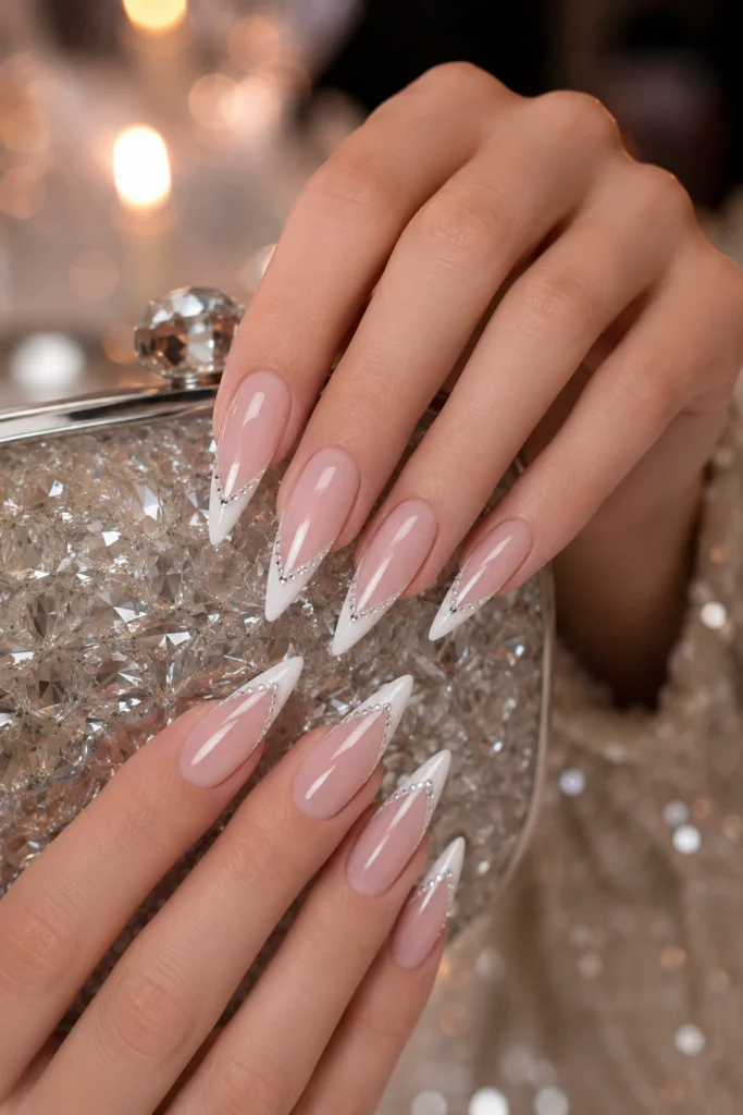 Long stiletto nails with white French tips and a row of tiny clear rhinestones