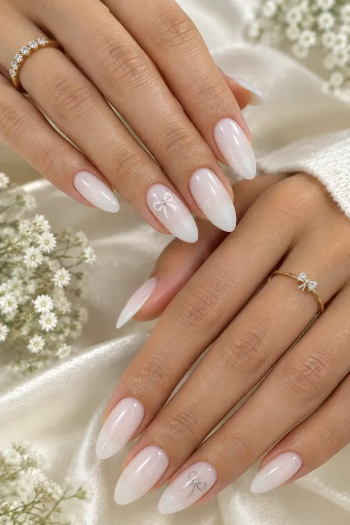 Sheer white manicure with delicate bow accents