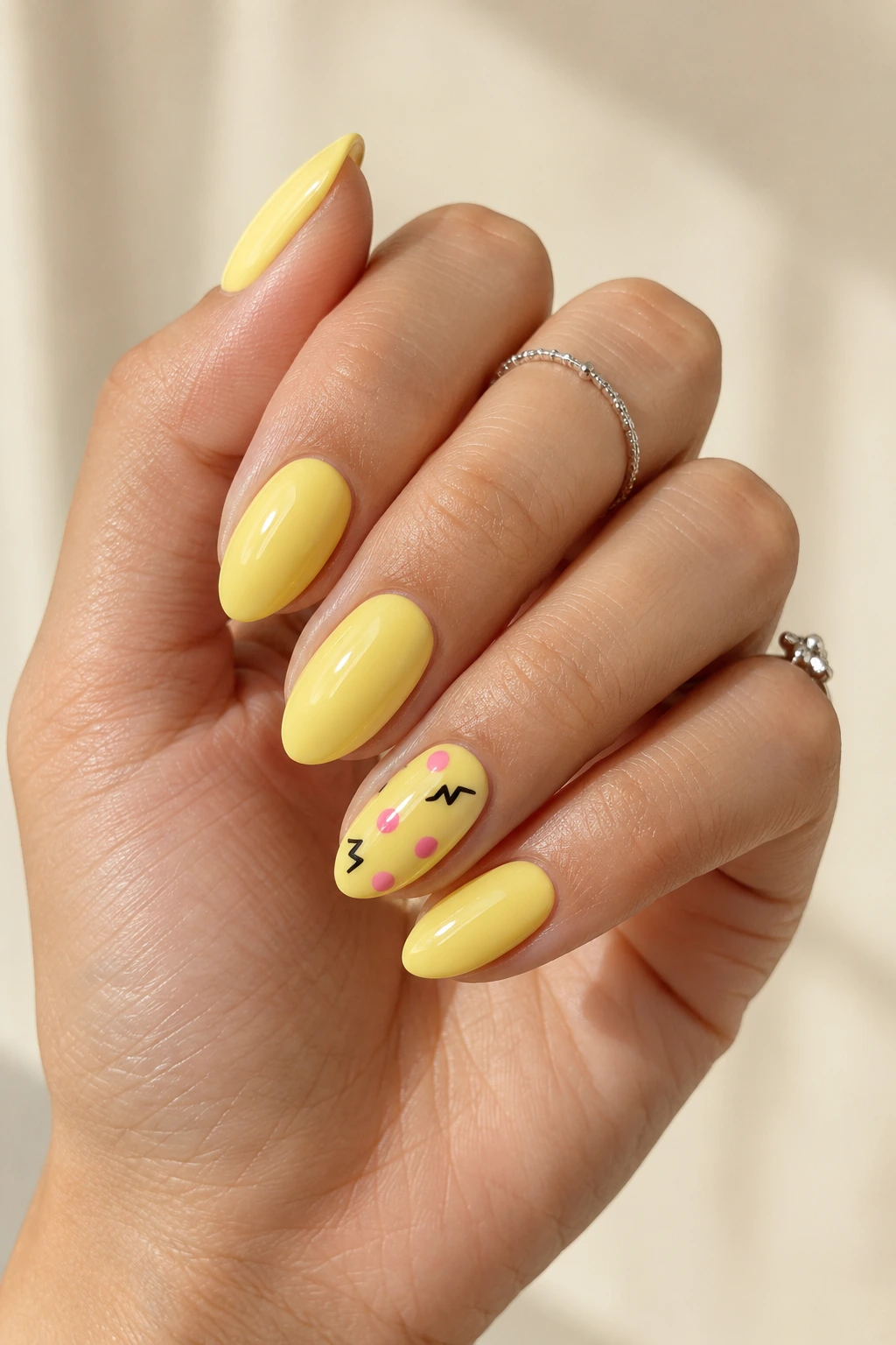 Yellow Pikachu nails with a cute character accent and red cheek details