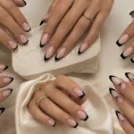 Classic black French tip nails on almond-shaped nails