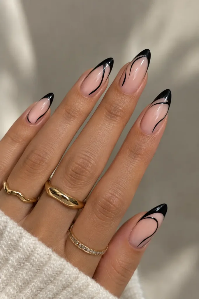 Nude nails with glossy black French tip swirl designs